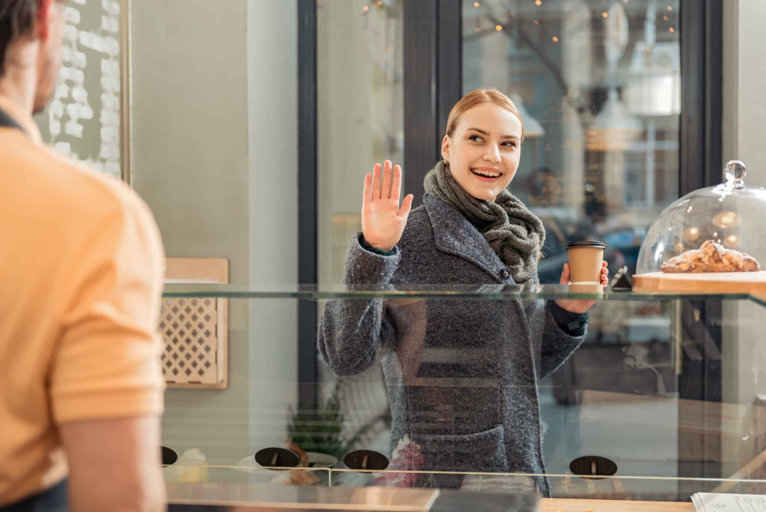 Carefree girl thanking salesman for espresso