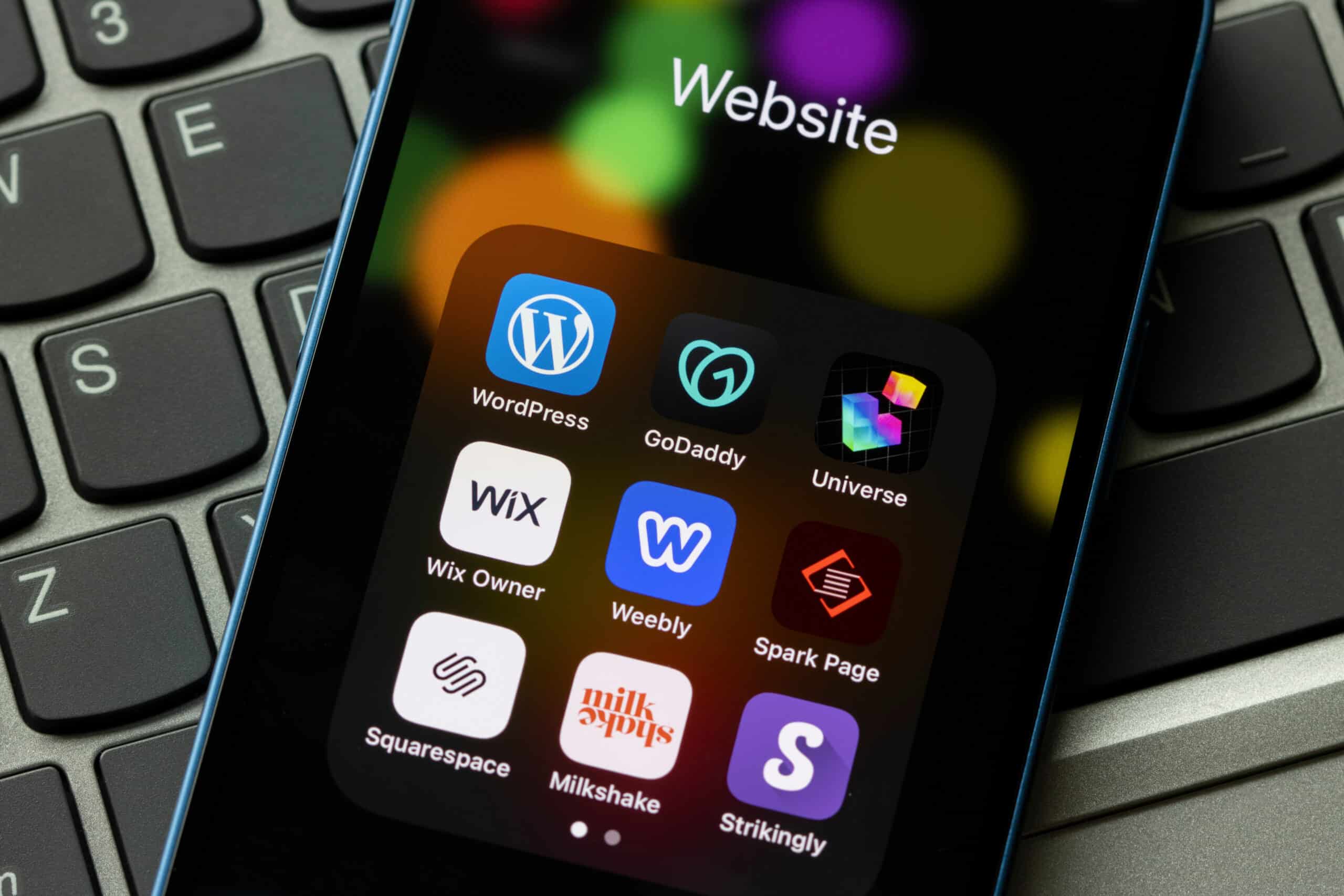 designing a mobile friendly website - Assorted website builders apps are seen on an iPhone