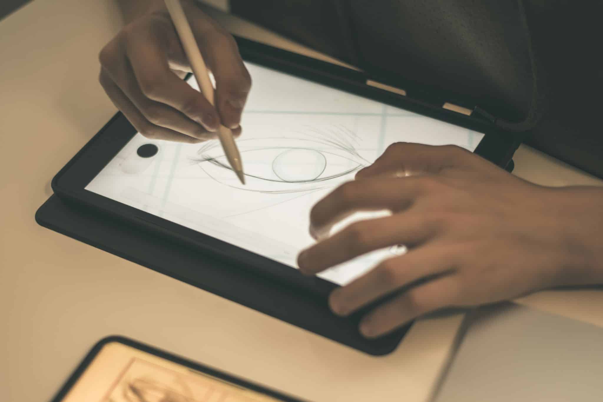 Teenager drawing with tablet and virtual pen. Millennial student doing homework with new technology devices. Young boy draw on pad at home. Male hands working with digital pencil on the touch screen. 