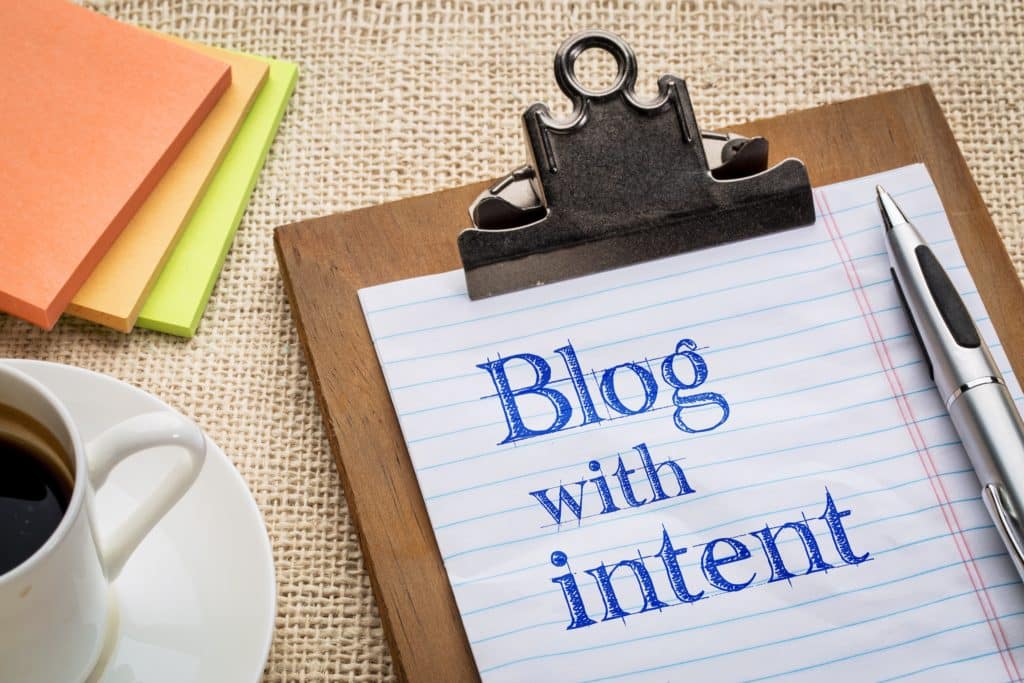 A clipboard that says "blog with intent" referring to the keyword commercial intent