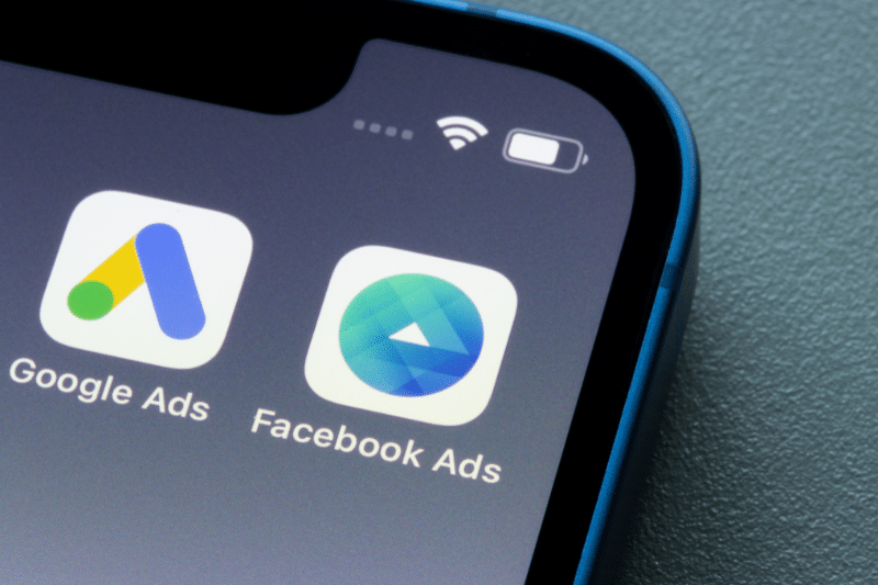 Facebook Ads Manager and Google Ads app icons are seen on an iPhone.